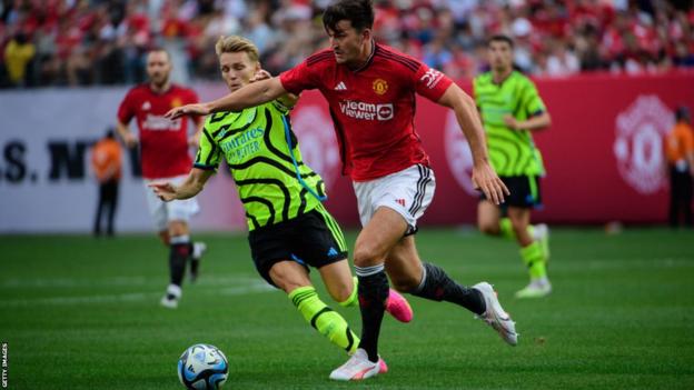 Harry Maguire del Manchester United lucha por el balón con Martin Odegaard del Arsenal