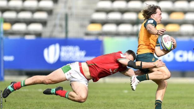 Darby Lancaster of Australia tackled by Louie Hennessey