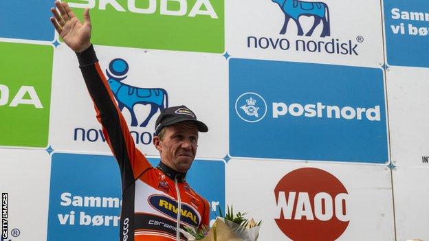 Chris Anker Sorensen waves on a podium