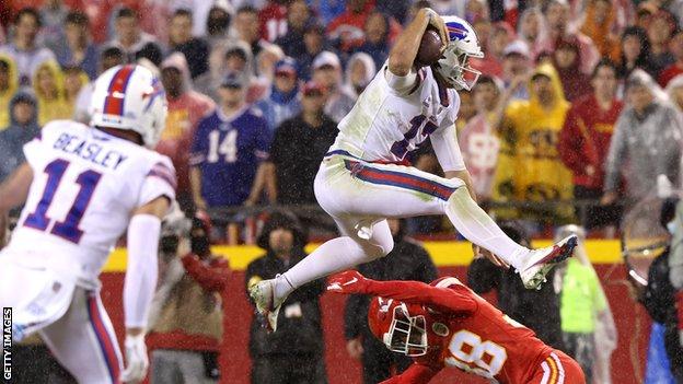 Josh Allen leaps over the defence of L'Jarius Sneed of the Kansas City Chiefs