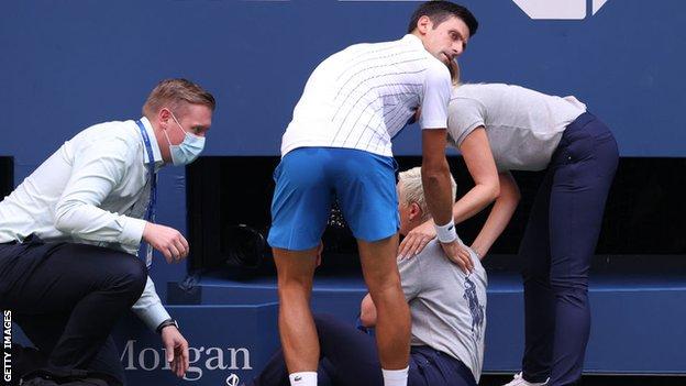 Djokovic tries to help an injured line judge at the US Open