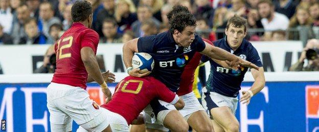 Scotland John Hardie (centre) is challenged by Frederic Michalak