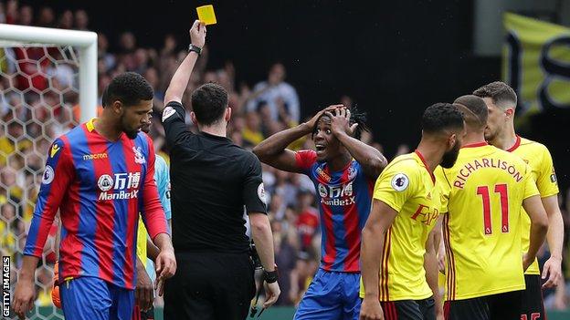 Crystal Palace winger Wilfried Zaha is incredulous after being booked for diving against Watford