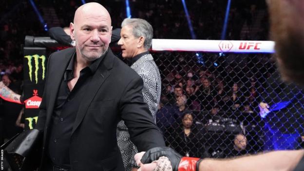 Dana White shakes hands with a fighter in the octagon