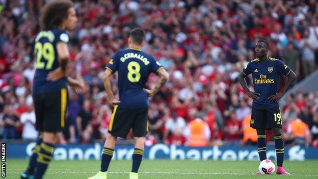 Arsenal players look disconsolate after conceding a third goal against Liverpool