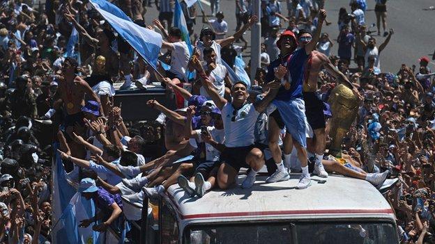 Argentina players dance and sing on top of the bus during their World Cup-winning parade in Buenos Aires