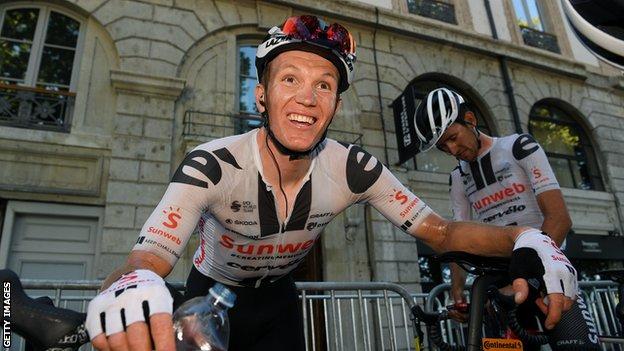 Soren Kragh Andersen smiles as he leans on his bike after winning stage 14 of the 2020 Tour de France