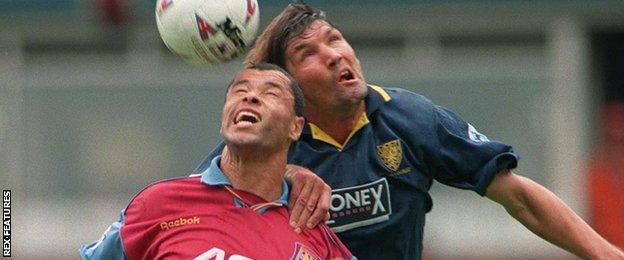 Mick Harford (right) contests a header