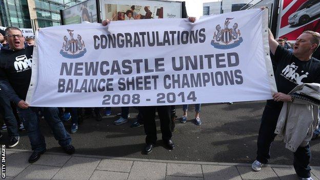 Fans hold a banner protesting against Newcastle's transfer policy