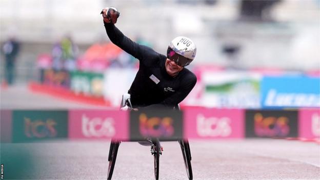 Marcel Hug celebrates winning the men's wheelchair race at the London Marathon