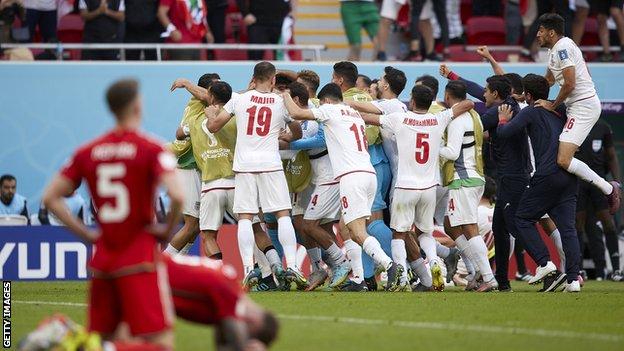Wales players sink to the turf after Iran's opening goal