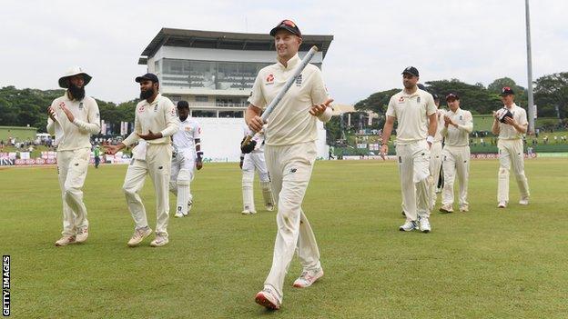 England captain Joe Root holds a stump as he leads his side off the pitch following victory over Sri Lanka in the second Test