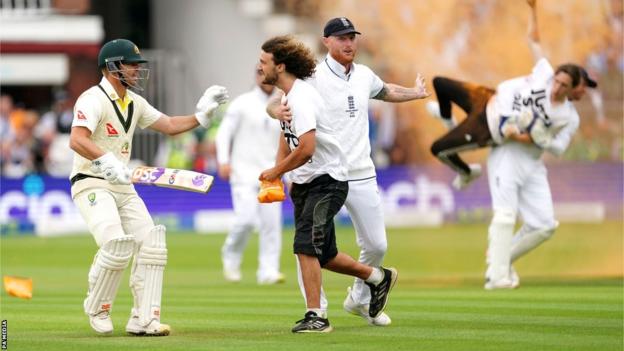 David Warner and Ben Stokes try to stop one protester as Jonny Bairstow is seen in the background carrying another off the field
