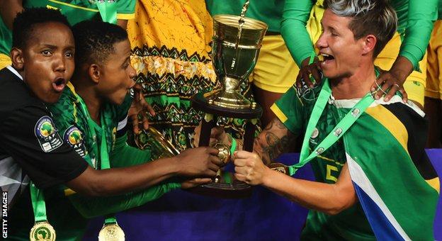 Andile Dlamini, Refiloe Jane and Janine van Wyk lift the Women's Africa Cup of Nations trophy for South Africa
