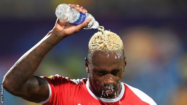 Guinea-Bissau's Frederic Mendy cools down by pouring a bottle of water over his head