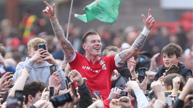 Wrexham's James McClean celebrates during the pitch invasion after sealing promotion