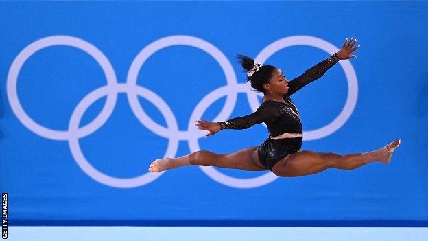 Simone Biles training in front of Olympic rings