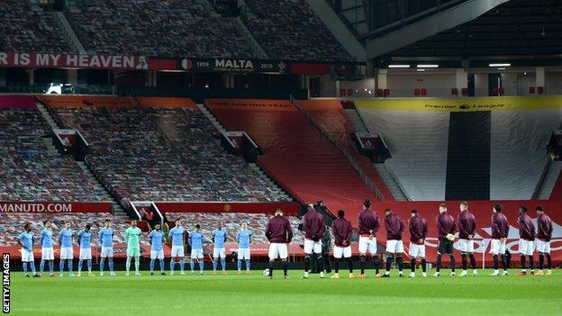 Manchester United and Manchester City player's observing a minute's silence for Colin Bell