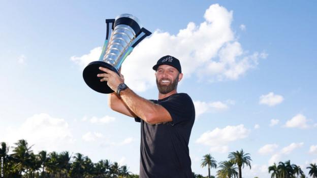 Dustin Johnson holds the inaugural LIV Golf Championship trophy.