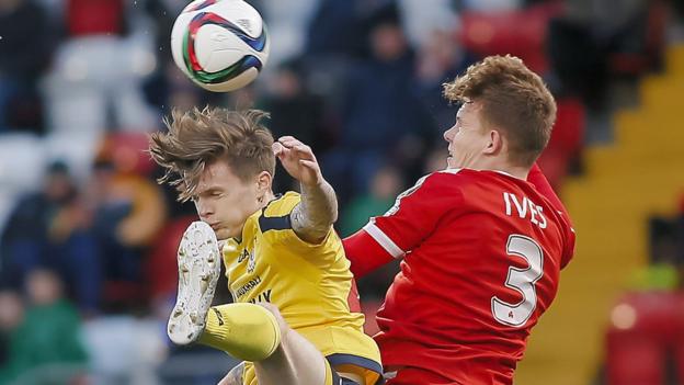 Dungannon Swifts striker Paul McElroy feels the full force of this collision with Cliftonville defender Levi Ives at Solitude