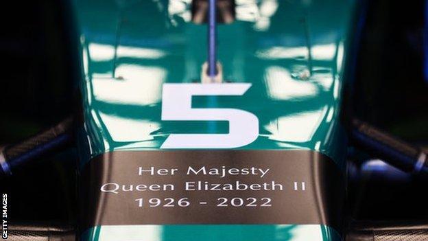 Aston Martin F1 car with message 'Her Majesty Queen Elizabeth II 1926-2022' written on nose