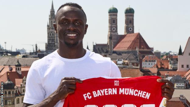 Sadio Mane holding a Bayern Munich shirt after joining the German club from Liverpool