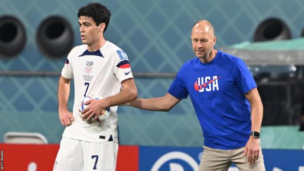 US midfielder Giovanni Reyna (left) receives direction from head coach Gregg Berhalter (right)