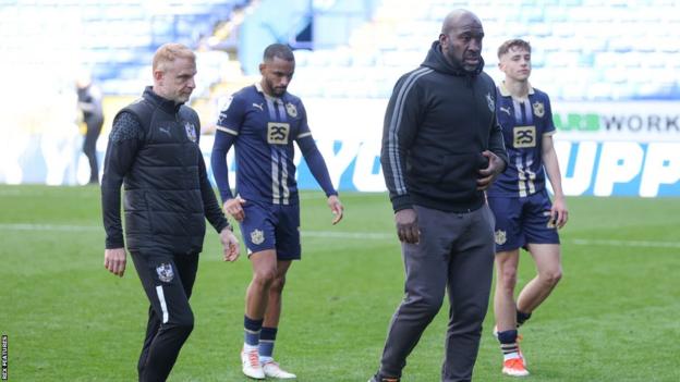 Darren Moore leads Port Vale players off the pitch after their relegation is confirmed