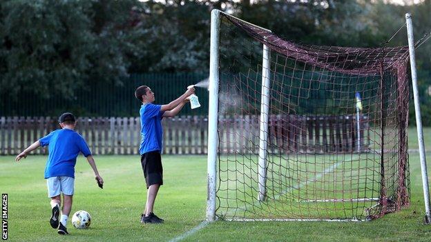 Children sanitise goalposts at Aylesbury Vale Dynamos FC