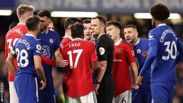 Manchester United and Chelsea players surround the referee