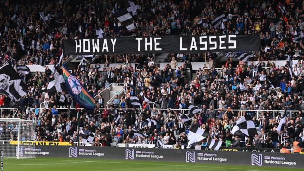 Partidarios sosteniendo una pancarta que decía 'cómo las muchachas' en St James' Park