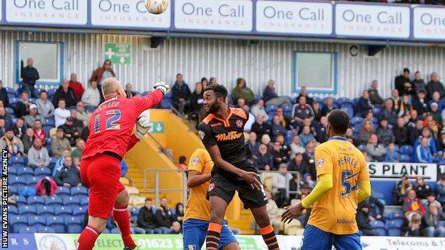 Brian Jensen of Mansfield clears the danger from Zak Ansa