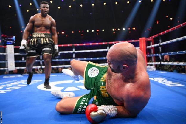 Francis Ngannou stands over Tyson Fury on the floor