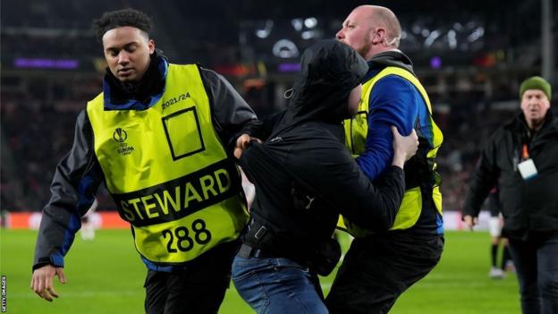 Pitch invader escorted off pitch by stewards during PSV v Sevilla