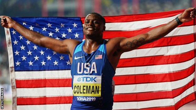 Sprinter Christian Coleman holds up the USA flag after winning the 100m title at the 2019 World Championships in Doha, Qatar
