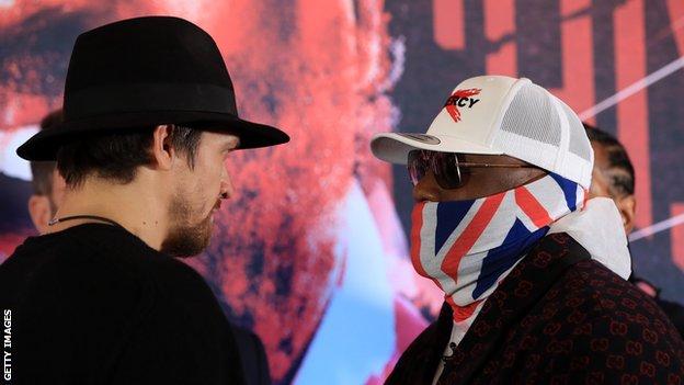 Oleksandr Usyk and Dereck Chisora face each other