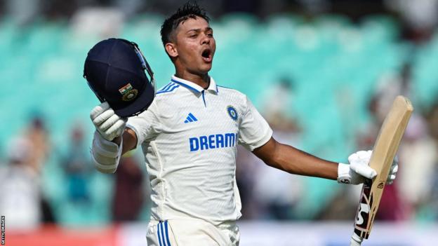 India opener Yashasvi Jaiswal raises his helmet and bat in celebration after hitting a century