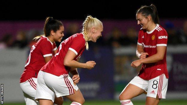 Manchester United players celebrate scoring against Durham