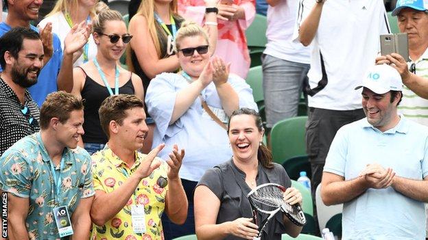 Woman in the crowd smiles as she is given Alexander Zverev's broken racquet at the 2019 Australian Open