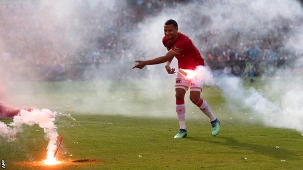 AZ Alkmaar's Ricardo van Rhijn clears fireworks off the pitch during the Dutch Cup final against Feyenoord