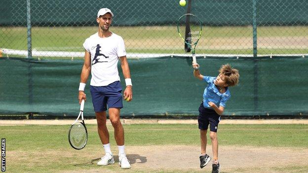 Novak Djokovic watches his son serve