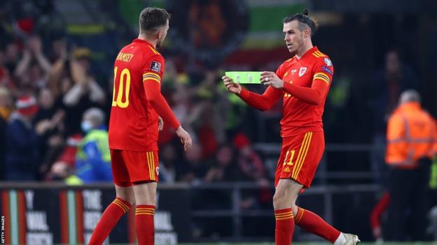 Aaron Ramsey is handed the armband by Gareth Bale