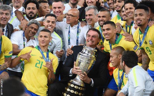 Bolsonaro poses with the Copa America trophy after Brazil's 2019 victory