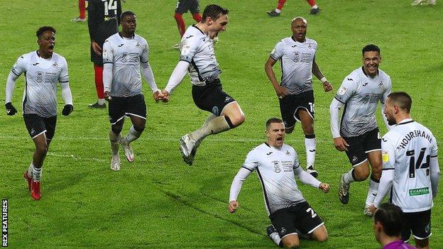 Swansea's players celebrate their late equaliser