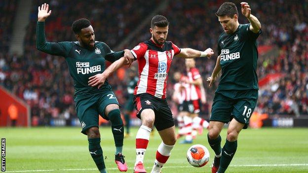 Shane Long of Southampton is challenged by Danny Rose and Federico Fernandez of Newcastle United