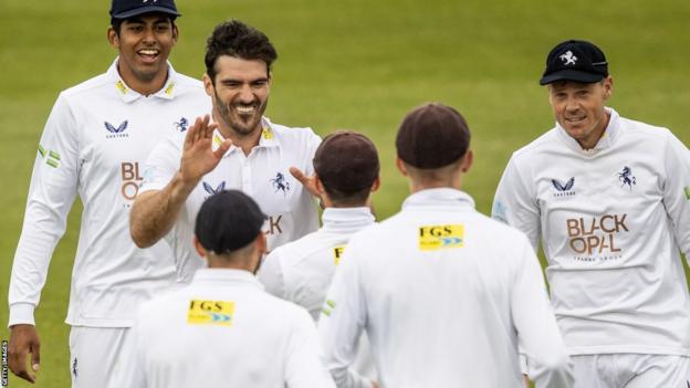 Grant Stewart (second from left) celebrates taking a wicket for Kent