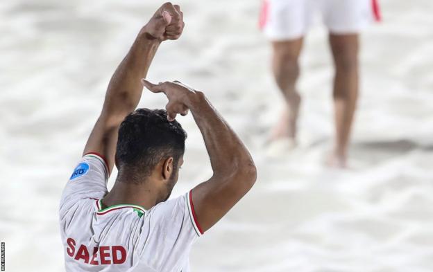 Le footballeur iranien de plage Saeed Piramoon fait semblant de se couper les cheveux