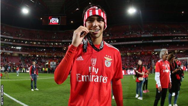 Joao Felix bites his league winner's medal after winning the title with Benfica