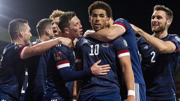 Che Adams (center) and Scotland players celebrate against Denmark