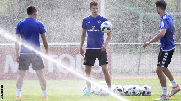 Paddy McNair manages to avoid the sprinklers during Monday morning's training session in Saint-Georges-de-Reneins